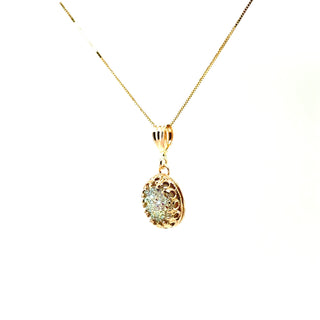 A white druzy queen pendant necklace on a 14k solid gold chain, displaying a sparkling, intricate pattern, side view